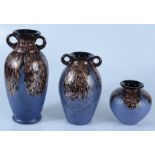Three blue and gold flashed glass vases, heights 25cm, 19.5cm and 12.5cm.