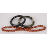 Two 'jade' bangles and a faceted 'amber' bead necklace.