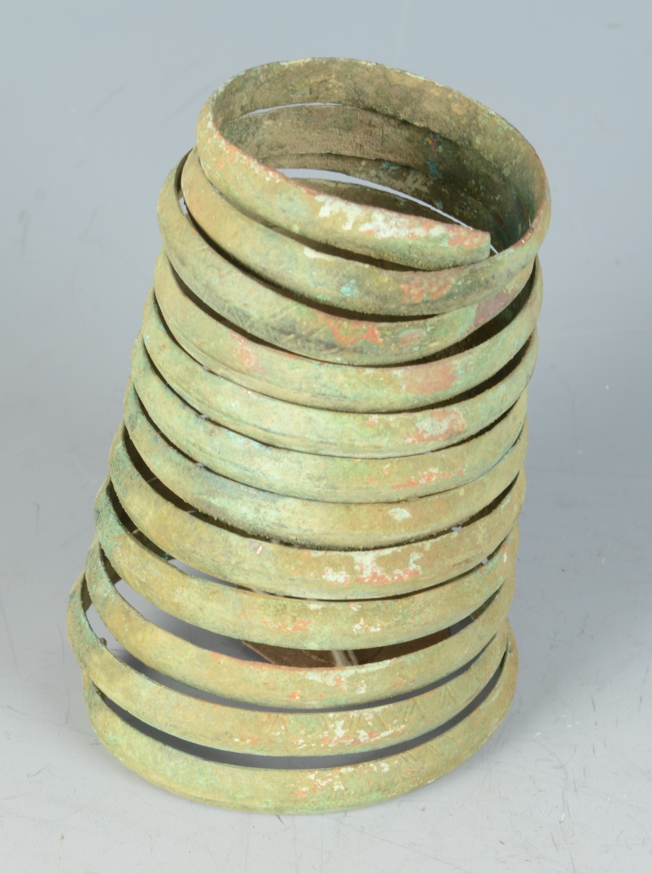 A spiral bronze bangle with incised decoration, possibly Celtic, length 11cm, widest diameter 7cm.