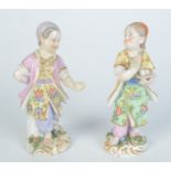 A pair of German porcelain hand painted figures, 19th century, of children holding eggs,