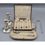 A pair of silver candlesticks, height 9cm, a cased set of six silver spoons,