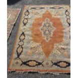 An Indian carpet, the terracotta ground with an indigo central medallion,