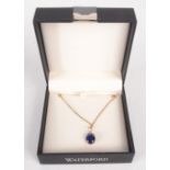 A gold pendant set with a cabuchon sapphire on gold chain.