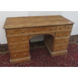 A Victorian pine pedestal desk, the rectangular moulded top above an arrangement of nine drawers,