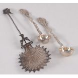 An ornate filigree spoon and a pair of salt spoons.