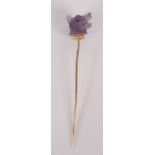 A stick pin with amethyst glass dog finial.