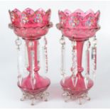 A pair of Victorian cranberry glass lustres, with gilt and painted enamel floral decoration,