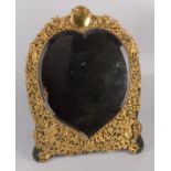 An impressive silver gilt heart shaped easel mirror by William Comyns showing an ornate arrangement
