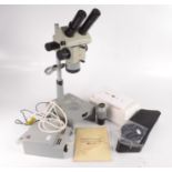 A Russian MbC-10 stereo microscope, with accessories and booklet, height 54cm.