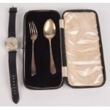 A gentleman's Cyma automatic nickel plated wristwatch and a child's silver spoon and fork.