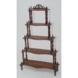 A mahogany five tier serpentine whatnot, with barley twist columns, height 122cm, width 73 cm.