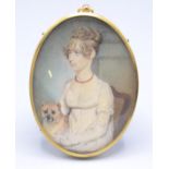 An early 19th century painted portrait miniature of a seated fashionable young lady her hair in
