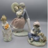 A Lladro group of a boy and girl, height 24cm and two other Lladro figures, heights 17cm and 14cm.