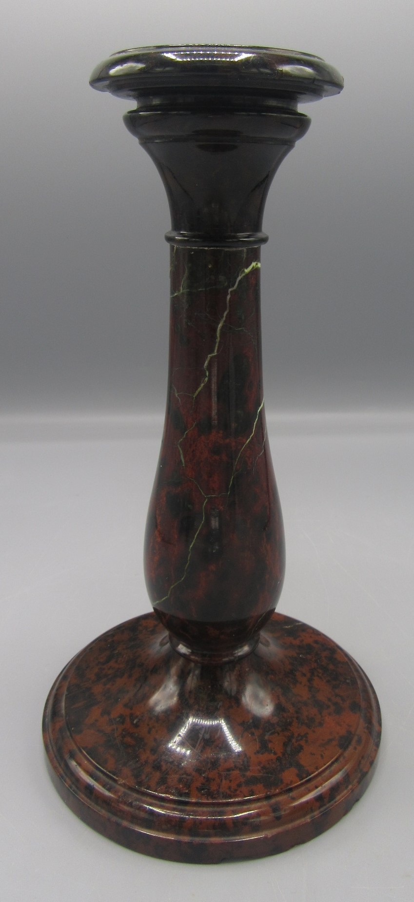 A Cornish serpentine candlestick, with a baluster stem on a circular plinth base, height 22cm,