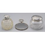 Two cut glass silver mounted toilet bottles and a small EPNS hand mirror.