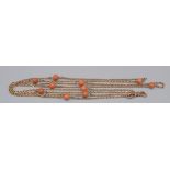 A 9ct gold long-guard chain spaced with red coral beads with double ended clip, 33.9g.