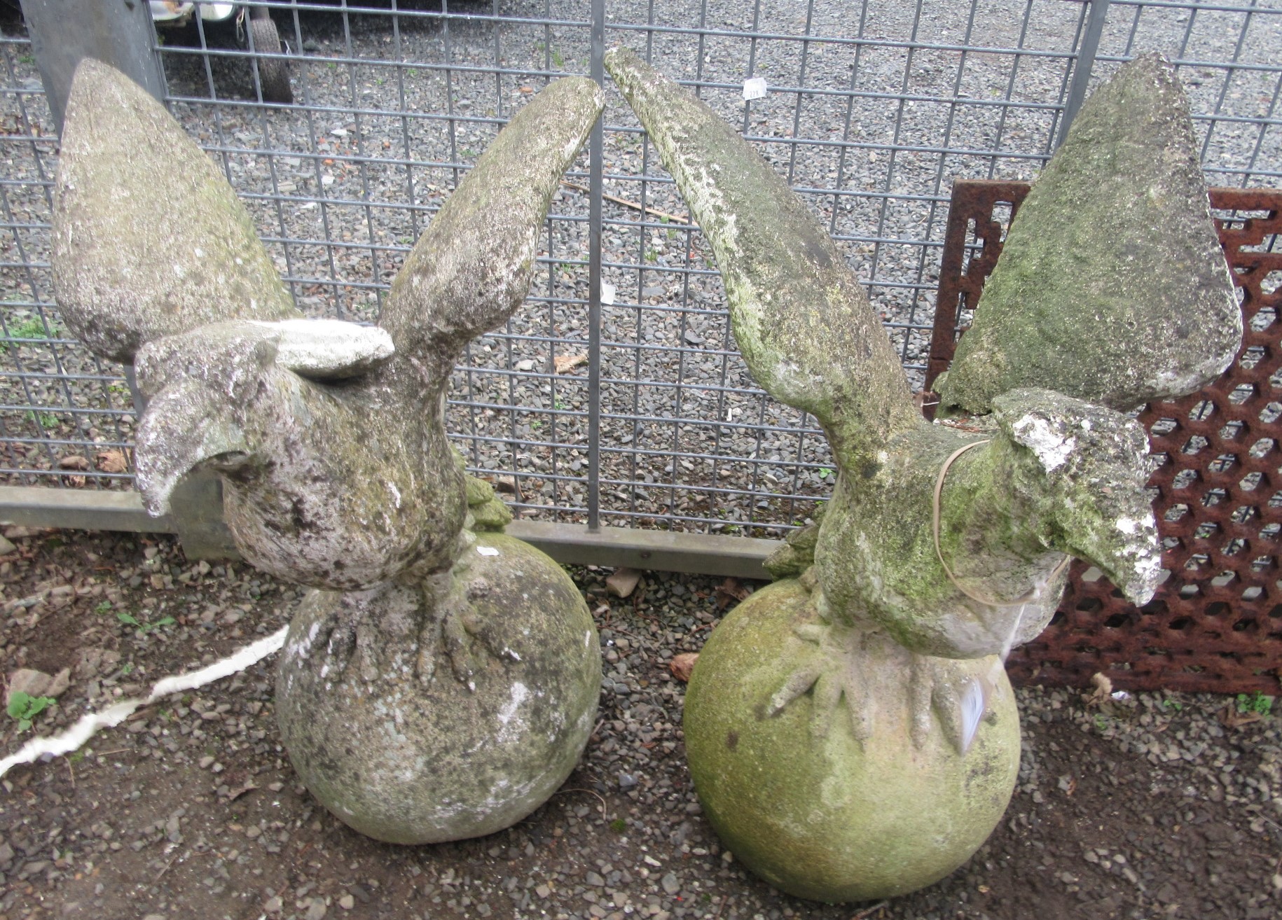 A pair of composition gate finials each moulded as a bird of prey.