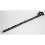 An African ebonised staff, the handle in the form of a cobra surmounted by an elephant,