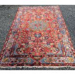 A Hamadan rug, the madder field with a central polychrome medallion,