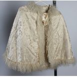 A ladies cream silk cape with sheepskin trim by G. Eyres & Sons, Bath, length 63.5cm.