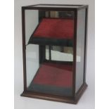 A mahogany glazed shop display cabinet, with a mirrored door to the rear and two sloping shelves,