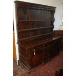 A George III oak Welsh Dresser, the rack with a pierced frieze and three shelves,