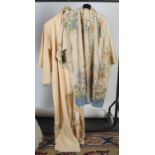 A fine cream silk, floral decorated dressing gown, with similarly decorated carrying bag,