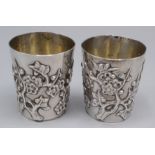 A pair of Chinese silver tots by Wang Hing showing flowering branches, 59g.