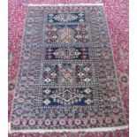 An Afghan rug, the indigo rectangular sectioned field decorated with guls and mihrabs,