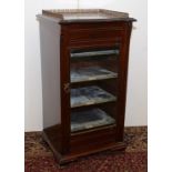 A late Victorian mahogany music cabinet with a gilt metal pierced gallery above a single glazed