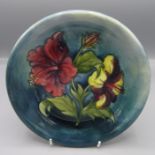 A Moorcroft Hibiscus pattern plate, impressed and painted marks, paper label, diameter 22cm.