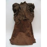 A dark brown silk ladies high necked top with balloon sleeves, decorated with brown velvet bows,