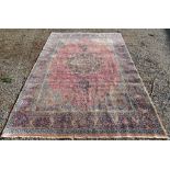 A Tabriz carpet, the pale madder field with a floral decorated polychrome medallion,
