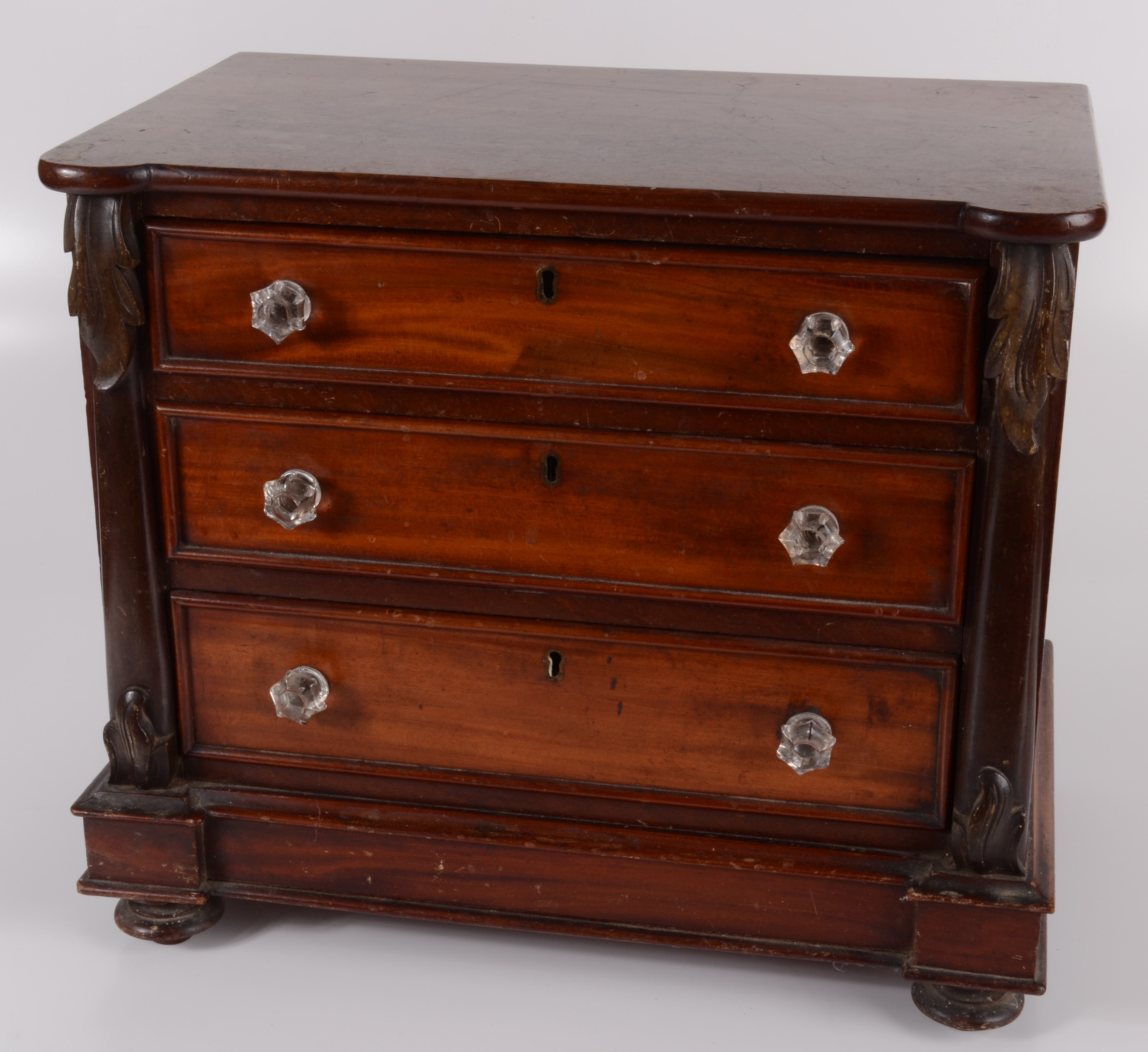 A Victorian mahogany miniature chest of drawers, with three long graduated drawers,