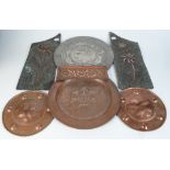 A pair of Arts and Crafts circular copper plaques, repousse decorated to the centre with fruit,