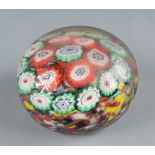A millefiori glass paperweight, with multi coloured canes, diameter 8cm.