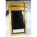 A Regency gilt wood wall mirror, with lion mask motifs above a rectangular bevelled plate,