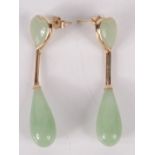 A pair of jade gold mounted earrings, each of heart form with a pendant drop.