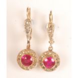 A pair of French gold earrings each with a ruby surrounded by diamonds.