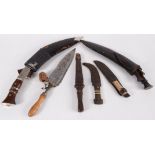 Two Kukri sets, each with leather scabbards, largest length 45.5cm and four daggers.