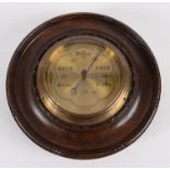 An oak cased wall barometer by Dollond, London, with a circular gilt metal dial, diameter 25.5cm.