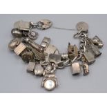 A silver bracelet mounted with many silver charms mostly of a novelty nature many opening, 100g.