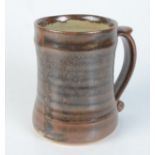 A Leach pottery brown glazed mug, impressed mark to base, height 12.2cm.