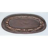 A Newlyn copper oval tray, the border repousse decorated with fish, shells and seaweed,