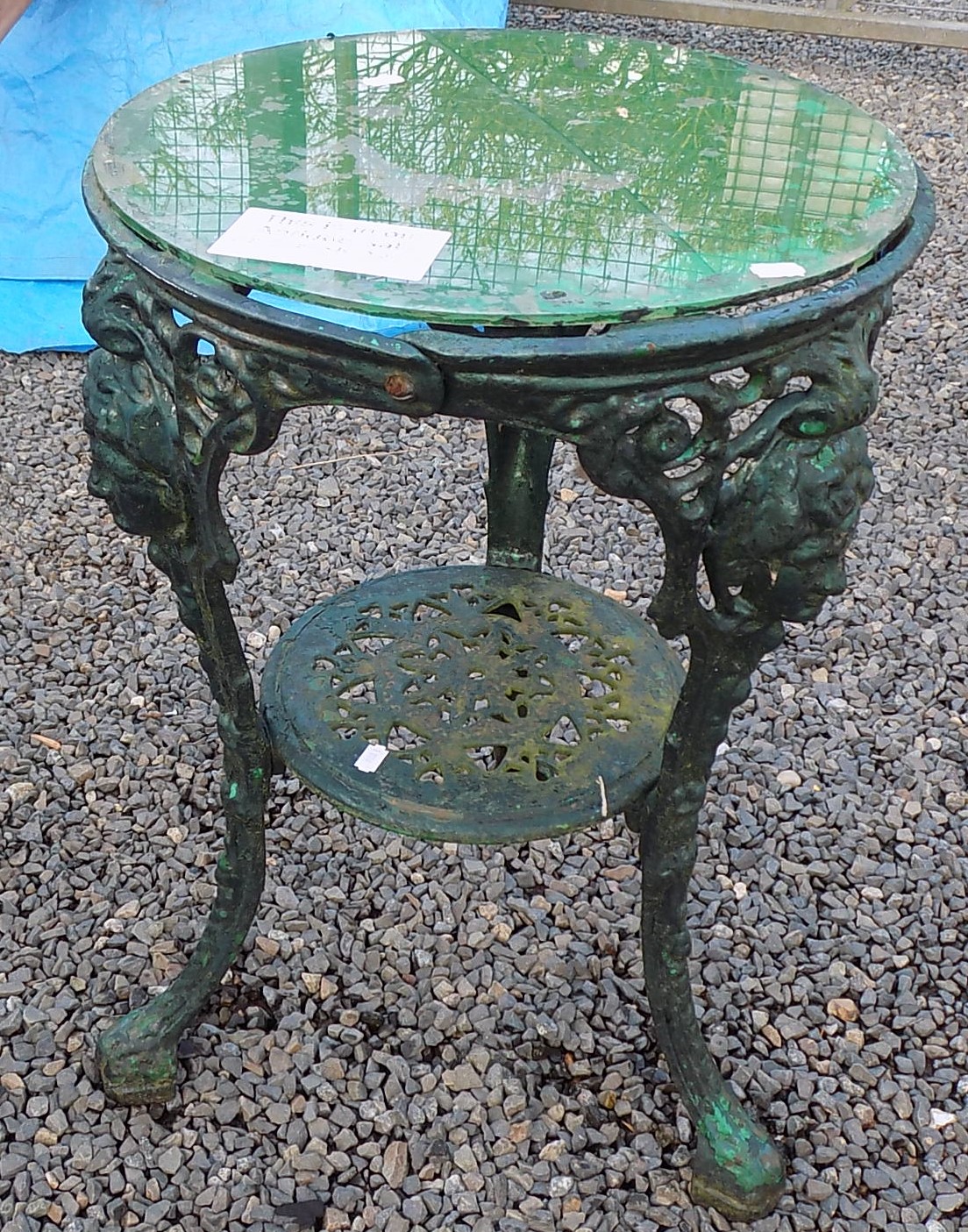 A green painted cast iron pub table, with a later circular plastic top,