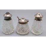A set of three cut glass silver mounted condiments.