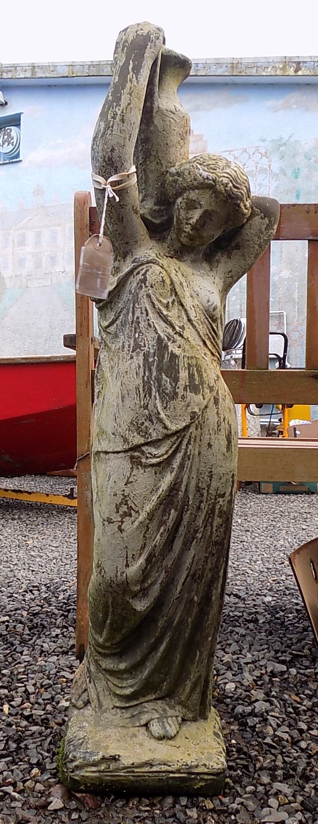 A composition garden statue of a female water carrier, height 91cm.