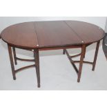 A Gordon Russell walnut D-end dining table, circa 1930, with one extra leaf,