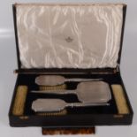 An Art Deco engine turned five piece dressing table set, cased, and a similar comb.