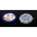 A micro-mosaic brooch showing ruins and an early Victorian brooch.